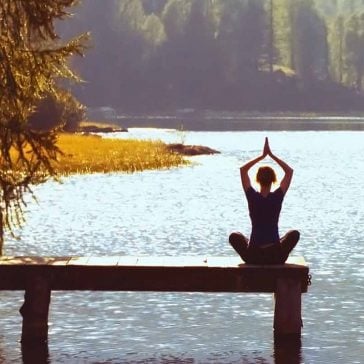 Person doing yoga by the water