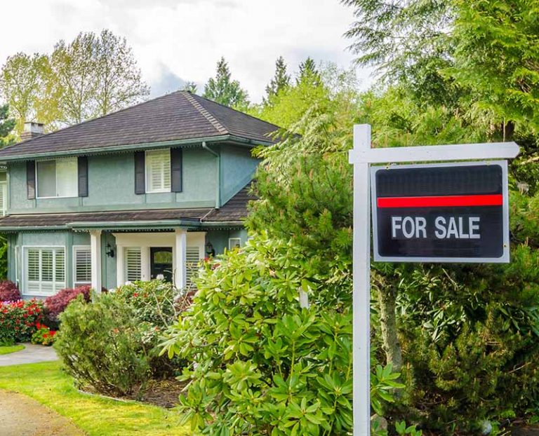 Estate agency 'house for sale' sign outside a country house