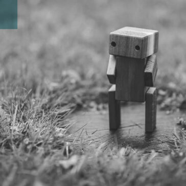 A wooden robot standing on the grass